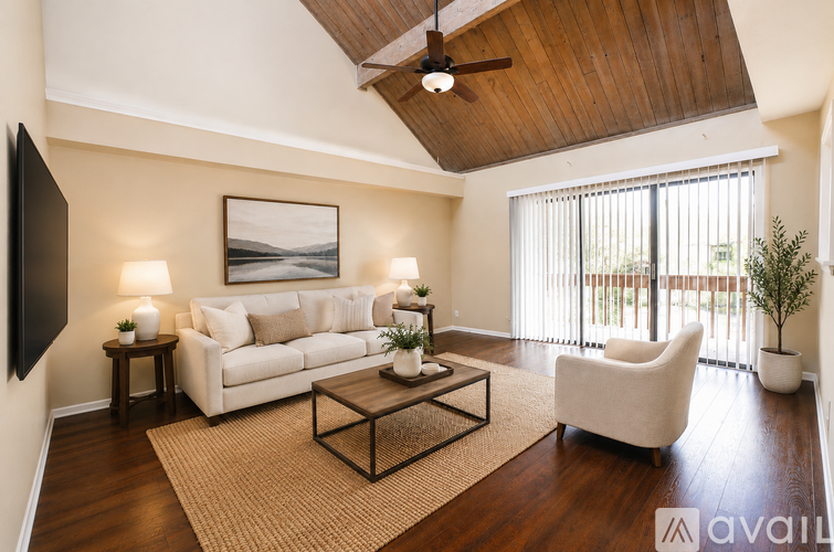 A living room with a white couch, a coffee table, and a ceiling fan.