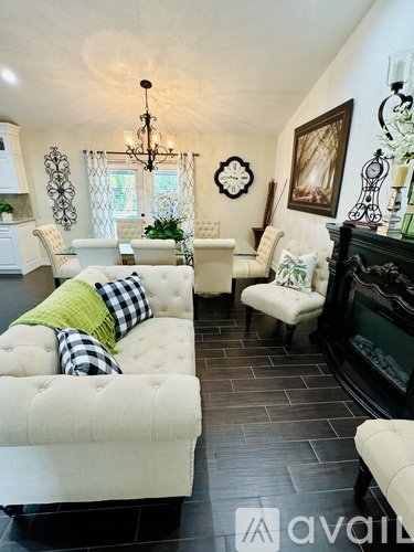 A living room with a white couch and a black fireplace.