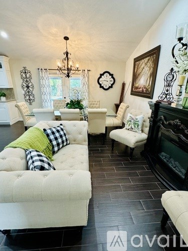 A living room with a white couch and a black fireplace.