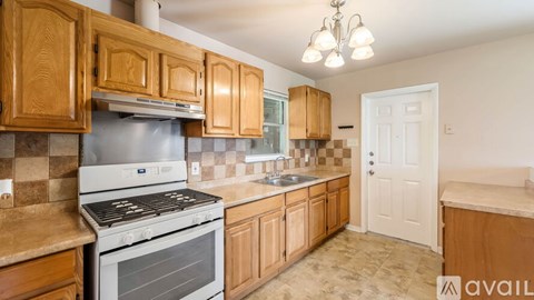 A kitchen with wooden cabinets and a stainless steel oven.
