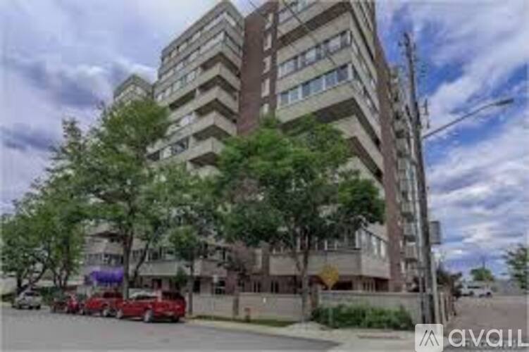 A tall building with a red car parked in front of it.