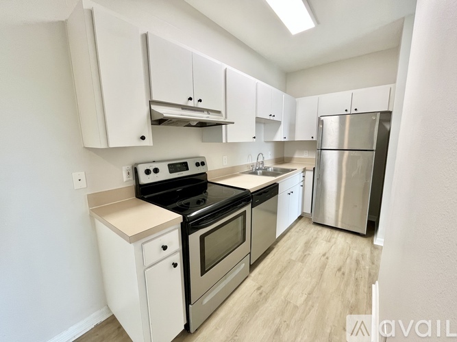 A kitchen with white cabinets and stainless steel appliances.