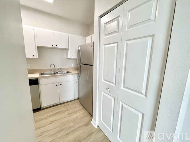 A kitchen with white cabinets and a refrigerator.