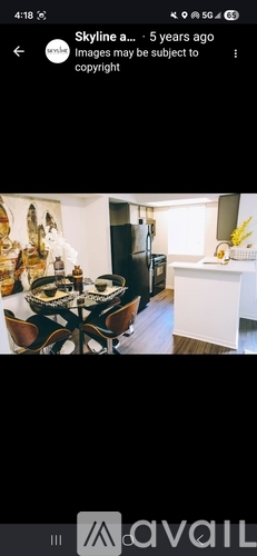 A dining table with chairs and a bowl of fruit on it.