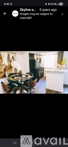 A dining table with chairs and a bowl of fruit on it.