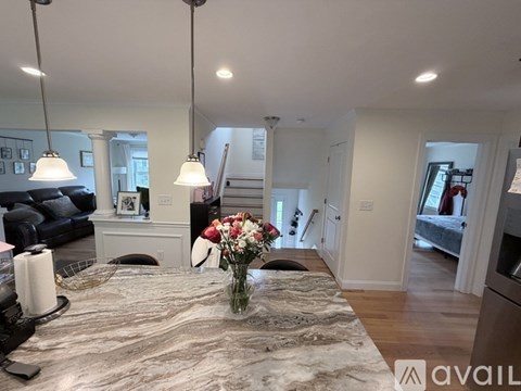 A modern living room with a grey rug and a vase of flowers on the table.