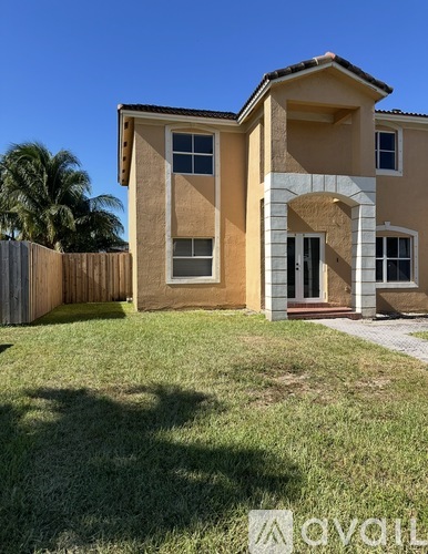 A two-story house with a brown and beige exterior and a white door.