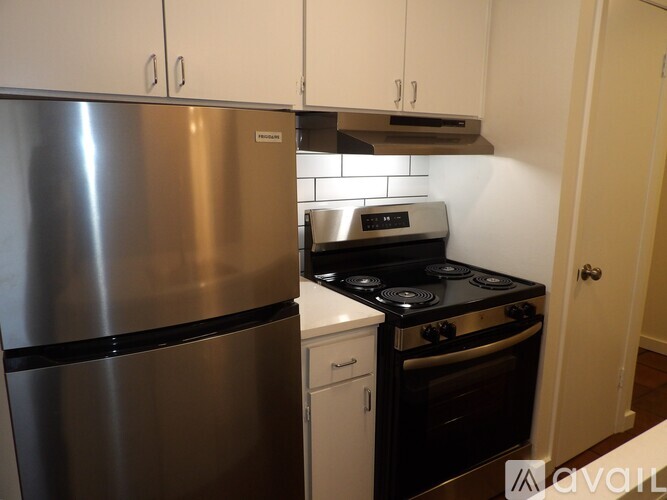 A kitchen with a stainless steel refrigerator and a black stove top oven.