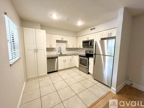 A kitchen with white cabinets and appliances.