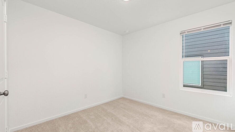 A room with a door and a window with blinds.