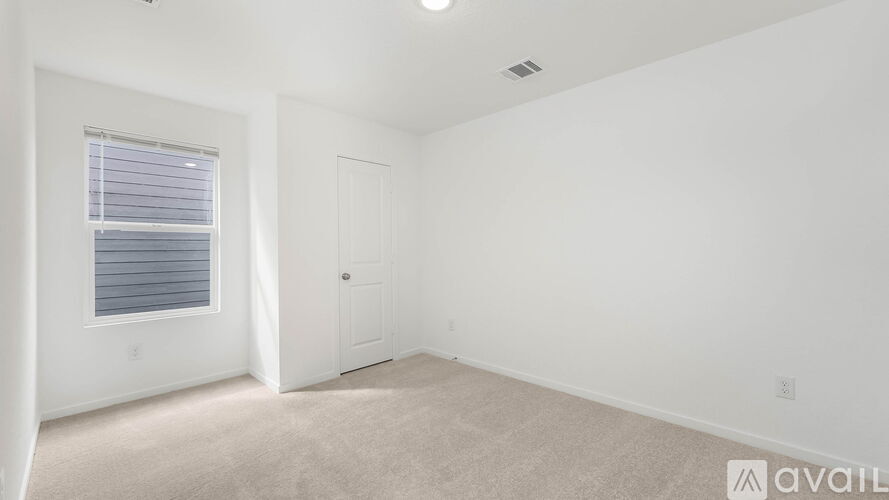 A room with a door, window, and carpeted floor.