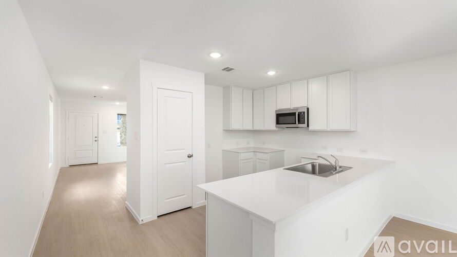 A kitchen with white cabinets and a countertop with a sink.