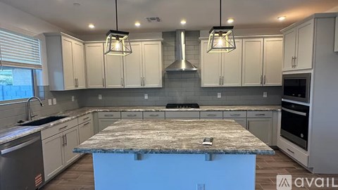 A kitchen with a granite countertop and white cabinets.