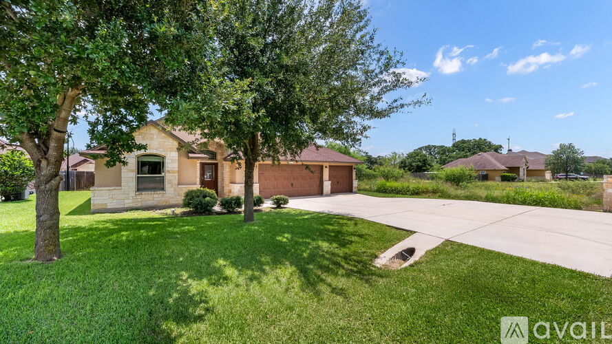 A house with a tree in front of it and a grassy lawn.