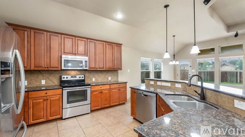 A kitchen with wooden cabinets and granite countertops.