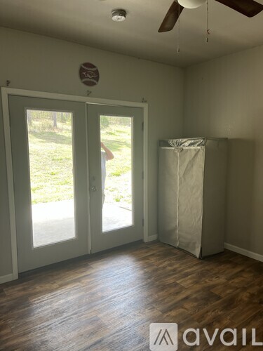 A room with a ceiling fan and a door leading outside.