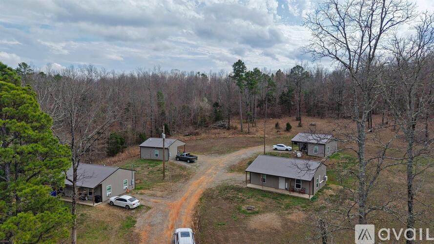 A bird's eye view of a property with two houses and a dirt road.