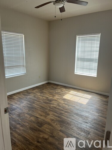 A room with wooden flooring and a ceiling fan.