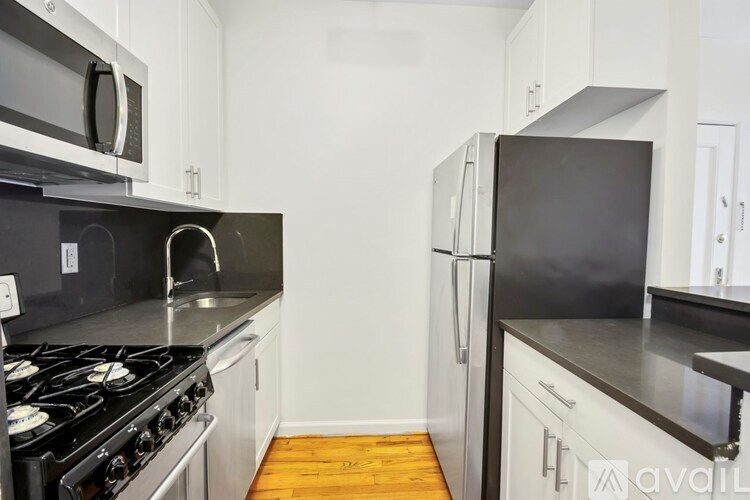 A kitchen with black countertops and white cabinets.