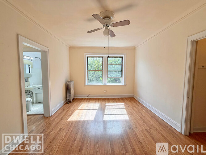 A room with a ceiling fan and a window.