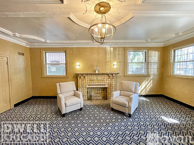 A living room with a fireplace and two chairs.