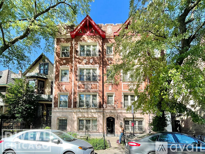 A building with a red roof and a tree in front of it.