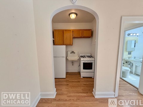 A kitchen with white appliances and wooden cabinets is shown.