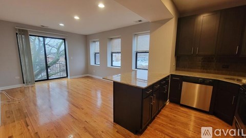 A kitchen with wooden floors and a large island with a sink.
