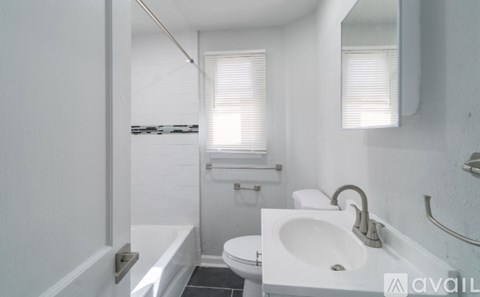 A white bathroom with a toilet, sink, and bathtub.