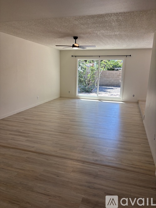 A room with wooden flooring and a ceiling fan.