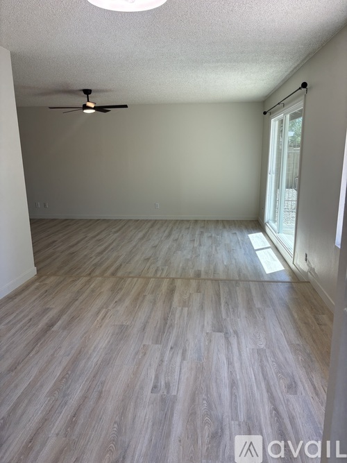 A room with wooden flooring and a ceiling fan.