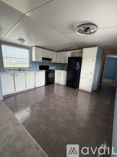 A kitchen with white cabinets and black appliances.