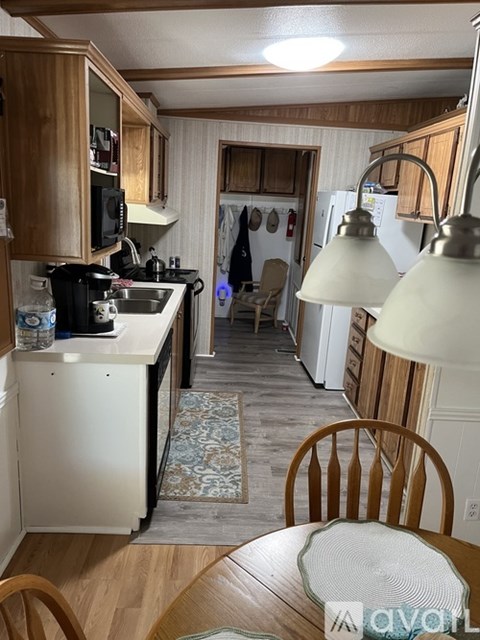 A kitchen with wooden cabinets and a white fridge.