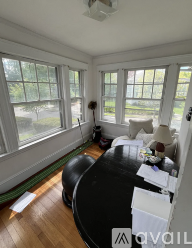 A room with a black table and a green rug.