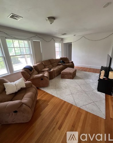 A living room with brown couches and a television.