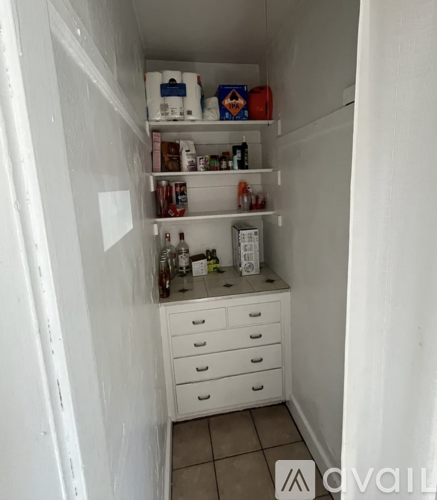 A small white kitchen with a refrigerator, a drawer, and a counter.