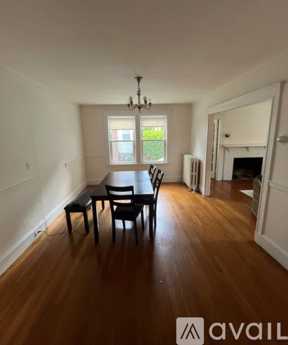 A dining room with a wooden table and chairs.