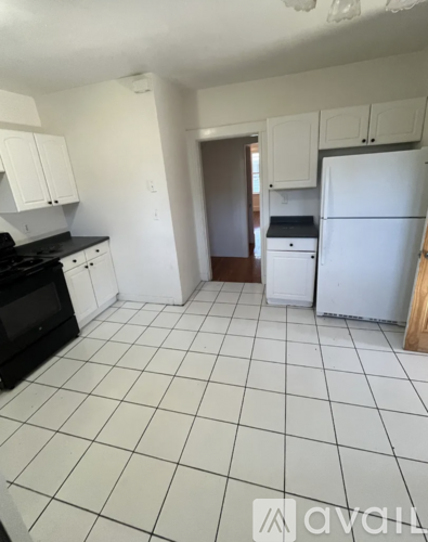 A kitchen with white cabinets and a black stove top.