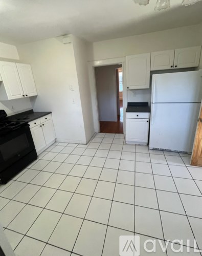 A kitchen with white cabinets and a black stove top.