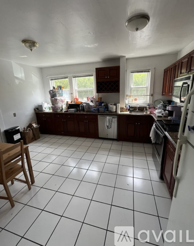 A kitchen with white tiled floors and wooden furniture.