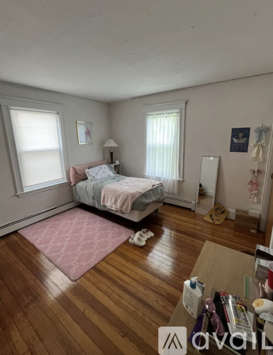 A bedroom with a bed, dresser, and window.