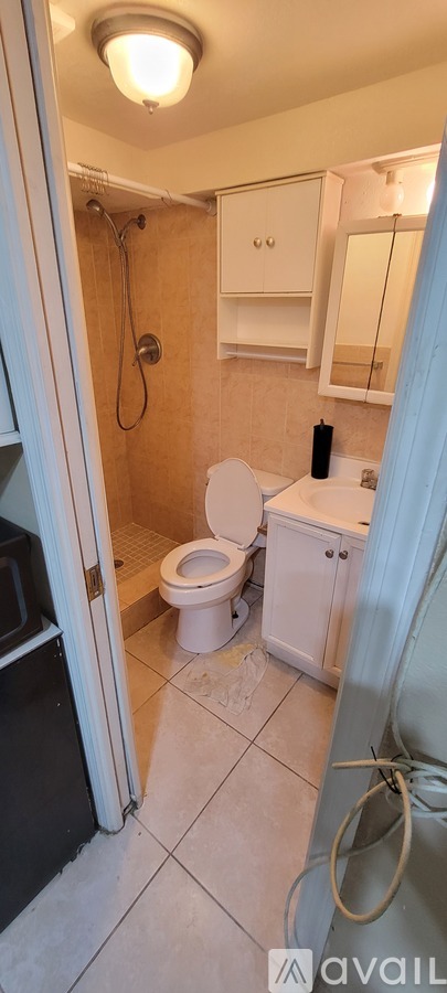 A room with a mattress and a fridge.