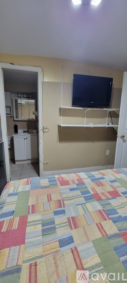 A bedroom with a bed and a television on the wall.