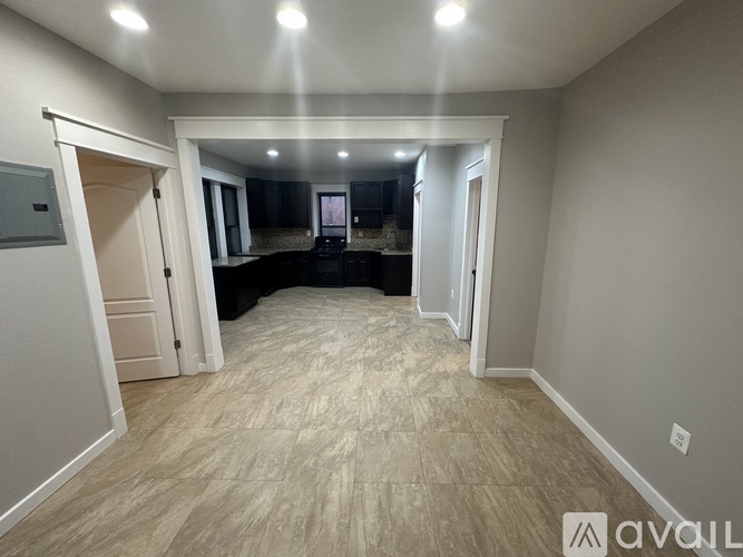 A spacious room with a carpeted floor and a row of lights on the ceiling.