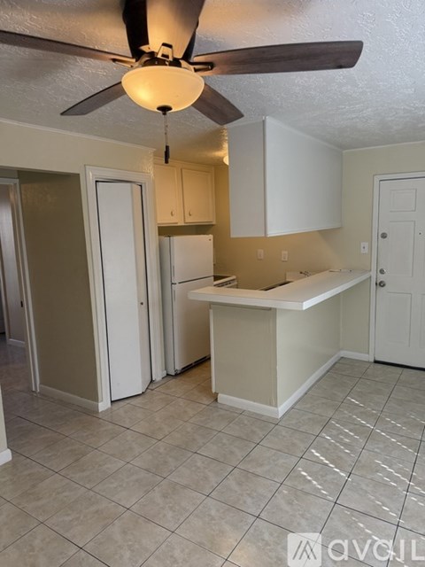 A kitchen with a fan hanging from the ceiling.