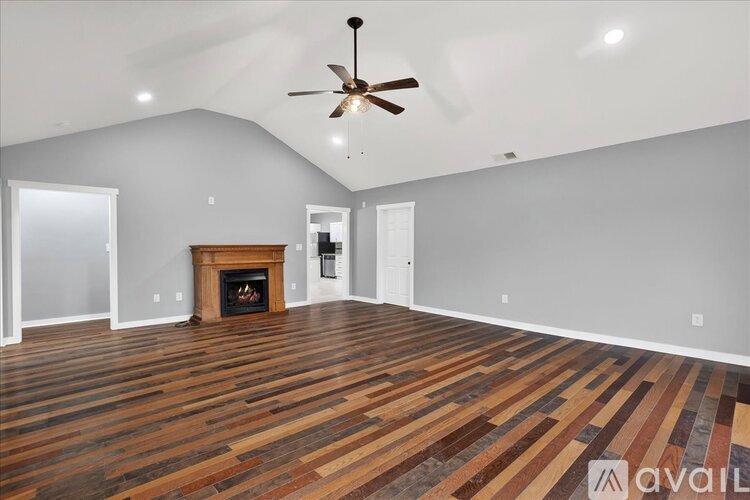 A living room with a wood floor and a ceiling fan.