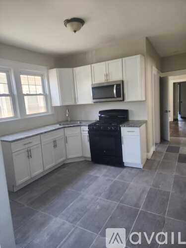 A kitchen with white cabinets and a black stove top oven.