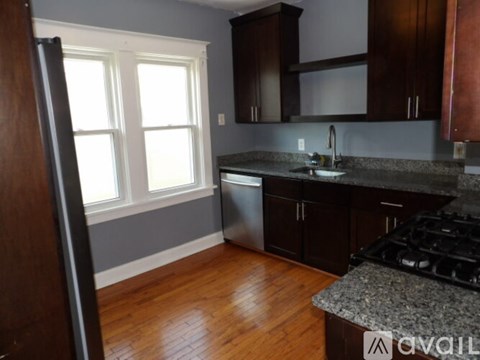A kitchen with wooden cabinets and a granite countertop.