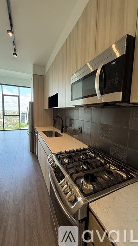 A modern kitchen with a stove, microwave, and oven.