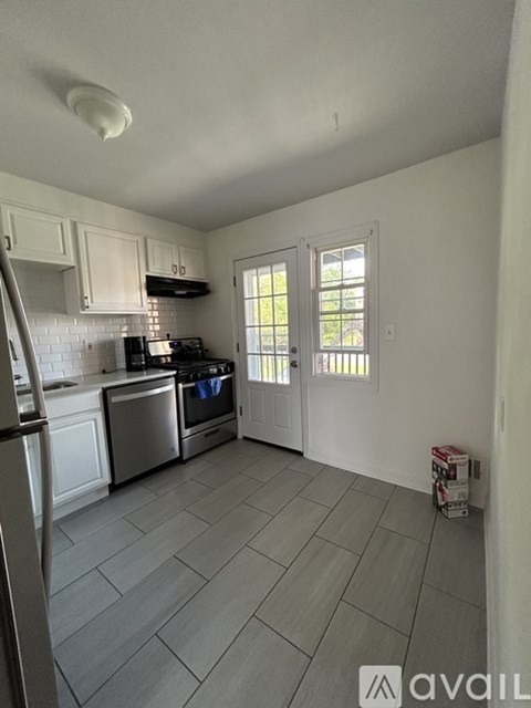 A kitchen with white cabinets and a tile floor.